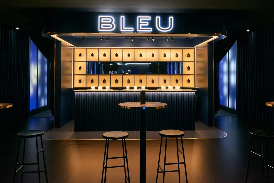 CHANEL Le Grand Numéro: la barra BLEU en un speakeasy azul oscuro con taburetes altos
