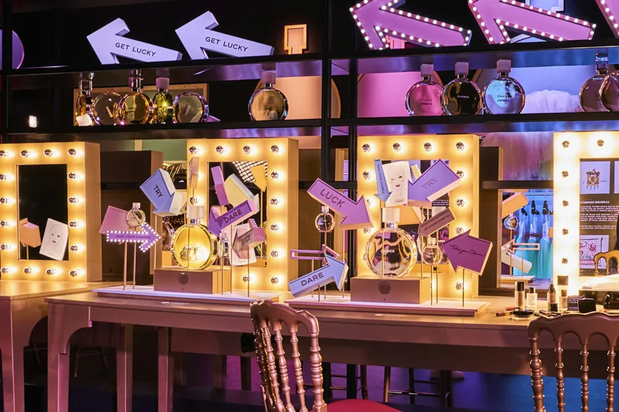 CHANEL Le Grand Numéro: decorado de cabaret para CHANCE con espejos de camerino, bombillas y una rueda de la fortuna