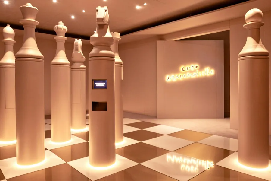 CHANEL Le Grand Numéro: piezas de ajedrez gigantes sobre un suelo ajedrezado en la sala de COCO MADEMOISELLE