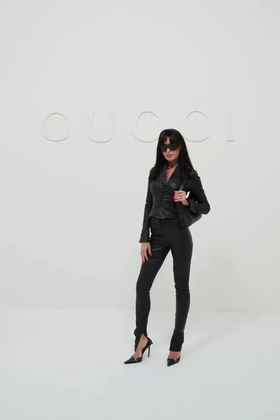 Gucci The Store Show: mujer vestida de cuero negro de pies a cabeza con un bolso de hombro negro