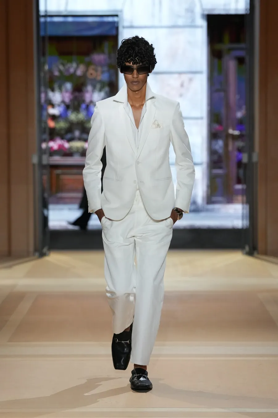 Gucci The Store Show: modelo con traje blanco y mocasines negros en la pasarela